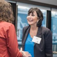 President Mantella smiling and engaged in conversation with woman in orange jacket